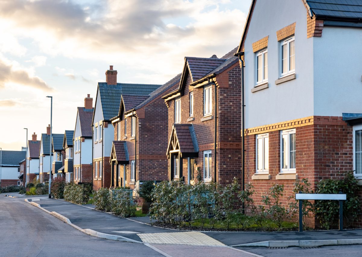 Houses in England with typical red bricks at sunset - Main street in a new estate with typical British houses on the side - Real estate and buildings concepts in UK